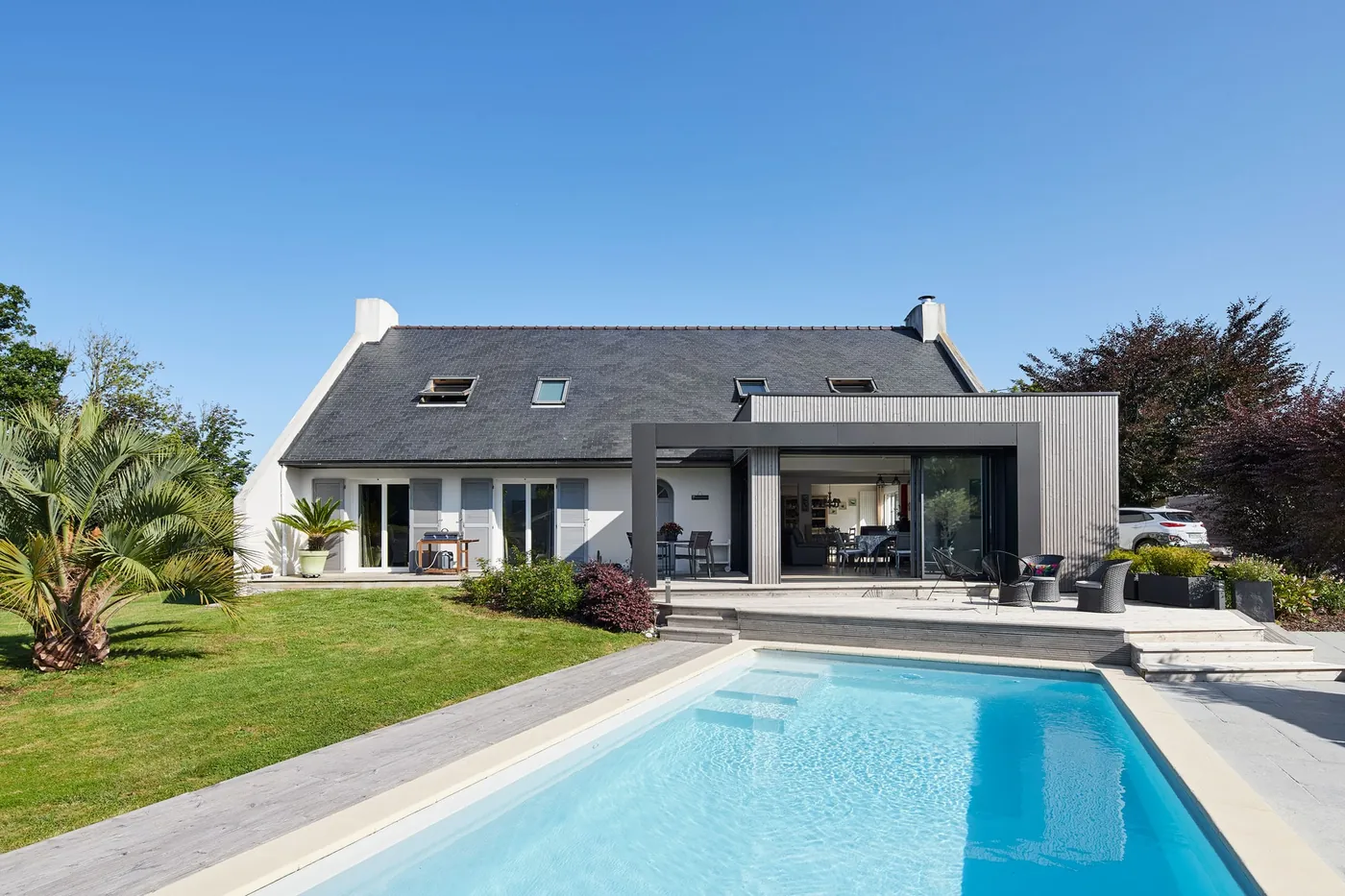 Maison néo-bretonne au crépi blanc agrandie d'une extension bois contemporaine